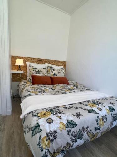 une chambre avec un lit avec une couette fleurie dans l'établissement Le Tropico - Clim - Terrasse - Proche Polygone, à Béziers