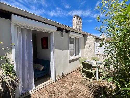 eine Terrasse mit Tisch und Stühlen auf einem Deck in der Unterkunft Le Tropico - Clim - Terrasse - Proche Polygone in Béziers
