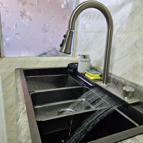 a kitchen sink with water pouring from a faucet at Casa cómoda y funcional in Peumo