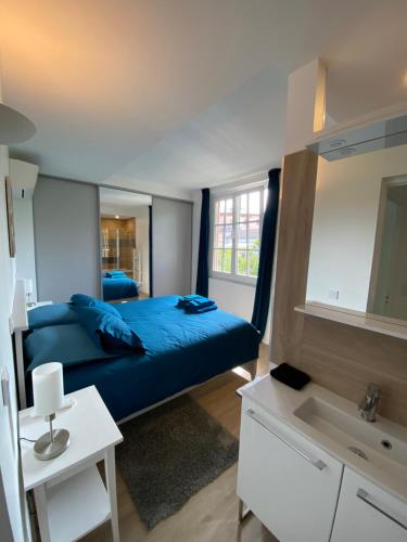 - une chambre avec un lit bleu et un lavabo dans l'établissement 3P calme en RDJ - Quiet 2 BR with large terrace, à Cannes