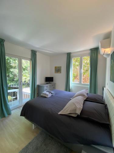 une chambre avec un grand lit avec des rideaux verts dans l'établissement 3P calme en RDJ - Quiet 2 BR with large terrace, à Cannes