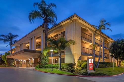 a large building with palm trees in front of it at Best Western Plus Orange County Airport North in Santa Ana
