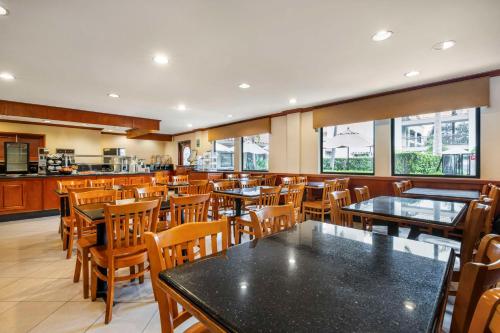 un restaurant avec des tables et des chaises et une cuisine dans l'établissement Best Western Plus Orange County Airport North, à Santa Ana