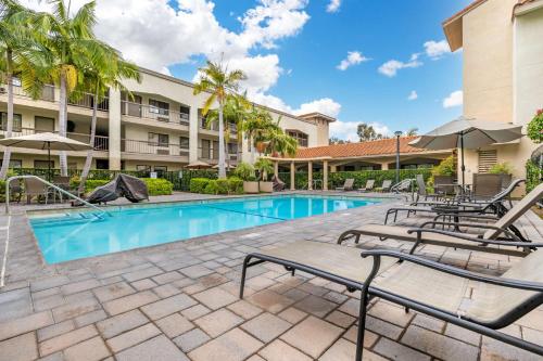 a swimming pool with chaise lounge chairs and a resort at Best Western Plus Orange County Airport North in Santa Ana