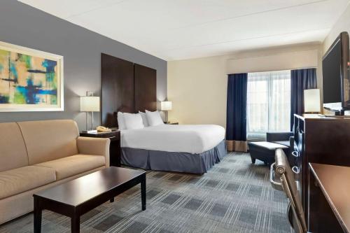 a hotel room with a bed and a couch at Best Western Hartford Hotel and Suites in Hartford