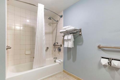 a bathroom with a tub and a shower with a shower curtain at Best Western Hartford Hotel and Suites in Hartford
