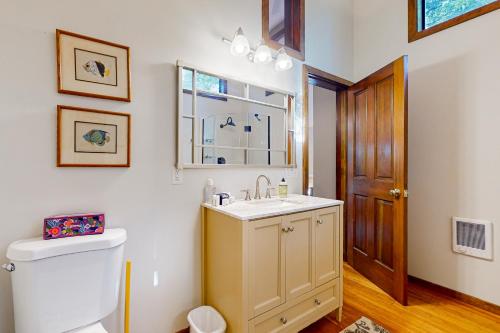 a bathroom with a sink and a toilet and a window at Raven Tree in Rosario