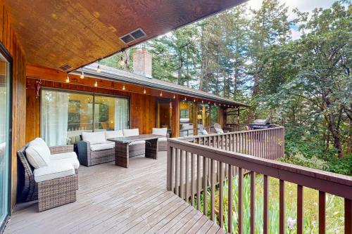 a deck with chairs and a table on a house at Raven Tree in Rosario