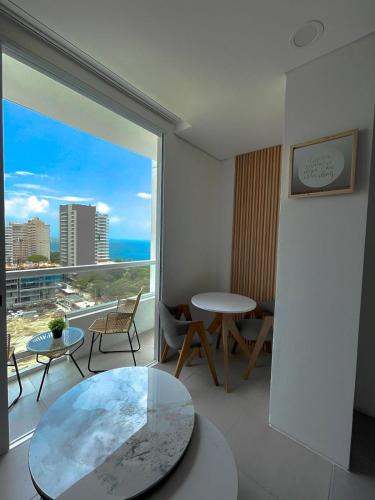 a room with a large window with a table and chairs at Suite con excelente vista al mar in Santa Marta