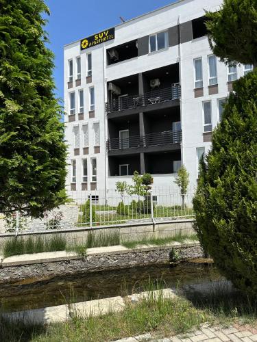 a tall white building with a balcony in front of it at SUV ApartHotel in Pogradec