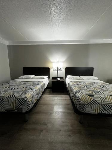two beds in a room with two lamps on the wall at Motel 6-Hazelwood, MO in Hazelwood