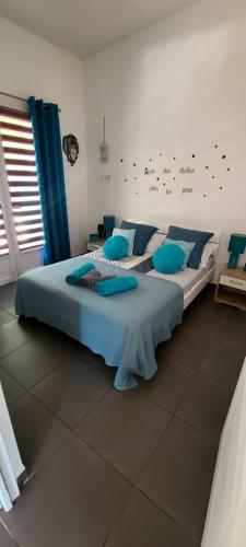 a bedroom with a large bed with blue pillows at villa Paty in Bonifacio