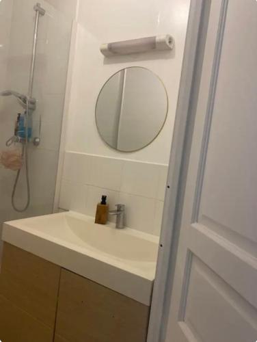 une salle de bain avec un lavabo et un miroir dans l'établissement Beau studio gare, à Montataire