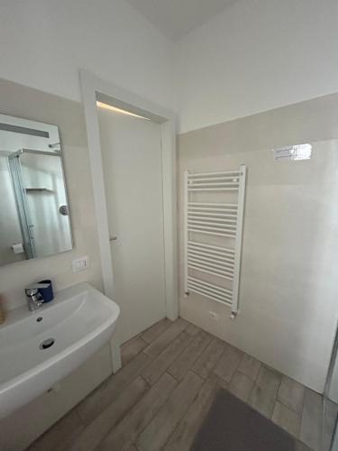 a white bathroom with a sink and a mirror at LE CASE DI AZZANO VICINO ALL'AEROPORTO DI ALICE E GIORGIA in Azzano San Paolo
