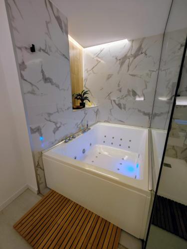 a white bath tub in a bathroom with marble walls at Sweet Suites in Valencia