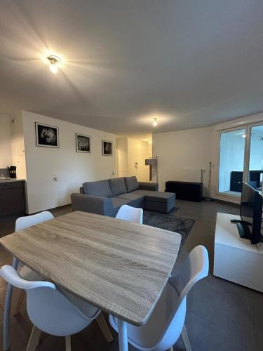 un salon avec une table et un canapé dans l'établissement Grand T3 spacieux, à Annemasse