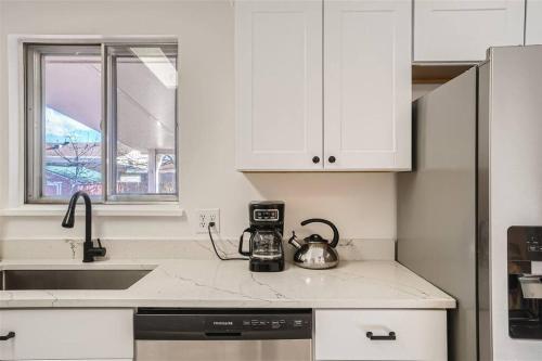 a kitchen with white cabinets and a tea kettle on a counter at Serene, Spacious Home in Quiet Neighborhood with Fenced Yard in Aurora