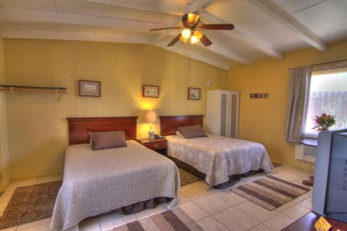 a bedroom with two beds and a ceiling fan at Harmony Motel in Twentynine Palms