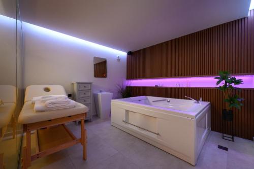 a bathroom with a tub and a sink and purple lighting at CorfuVille Luxury Villas in Danilia