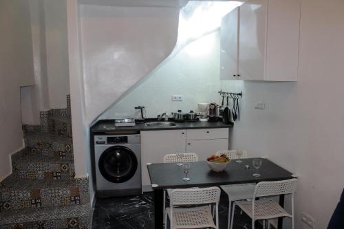 a small kitchen with a sink and a washing machine at CASA LUNA in the heart of old medina in Tangier