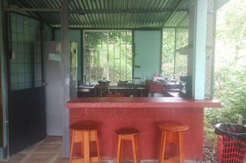 a kitchen with a red counter with two stools at viajero solitario in Buenos Aires
