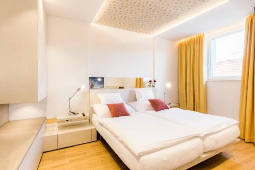 a bedroom with a large white bed in a room at Vienna Grand Apartments DANUBE in Vienna