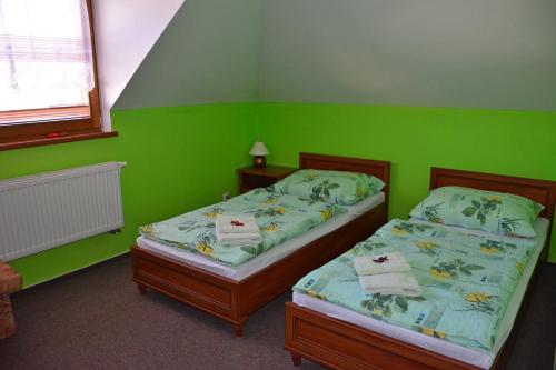 2 Betten in einem grünen Zimmer mit grünen Wänden in der Unterkunft Guest House Penzión Milka in Smižany