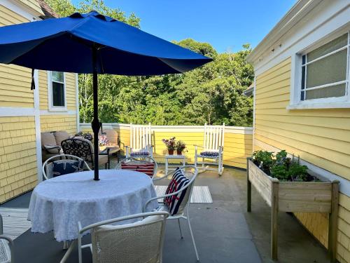 a table with a blue umbrella on a patio at Inn at the Oaks in Eastham