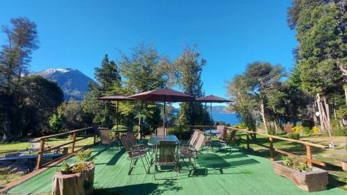 a patio with chairs and tables and an umbrella at CASA del LAGO Bariloche in San Carlos de Bariloche