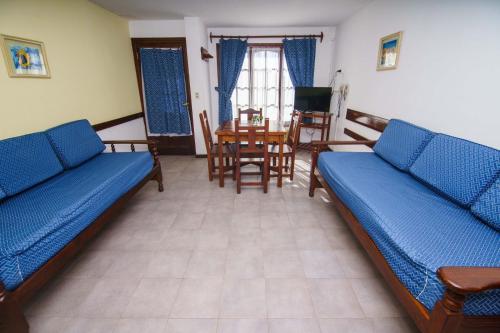 a living room with two beds and a table at CASA del LAGO Bariloche in San Carlos de Bariloche