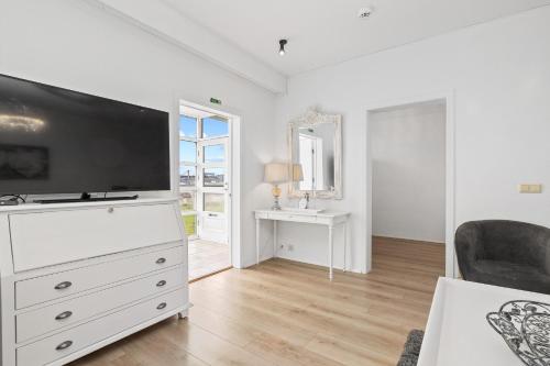 a living room with a large tv on a dresser at River Apartments in Selfoss