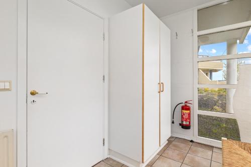a white hallway with a window and a fire extinguisher at River Apartments in Selfoss