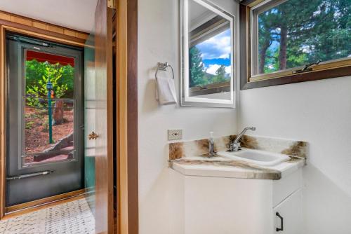 a bathroom with a sink and a window at Pikes Peak Stone Cottage - Hot Tub & Game Room in Cascade-Chipita Park
