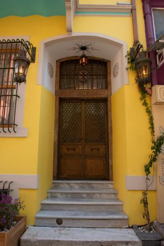 a yellow house with a wooden door and stairs at İstanbul Eagle's Nest Boutique Hotel in Istanbul
