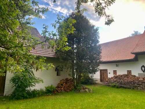 a white house with a tree in the yard at Stylově romantická venkovská chalupa Mlýnské Struhadlo in Mlýnské Struhadlo