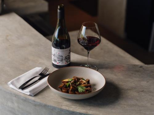 a bowl of food and a glass of wine on a table at Re’em Yarra Valley in Gruyere