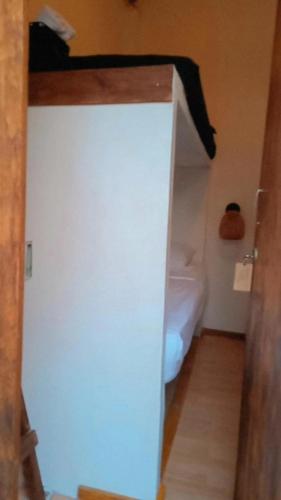 a room with a white wall and a bed at HOSTAL LA BOQUILLA in Cartagena de Indias