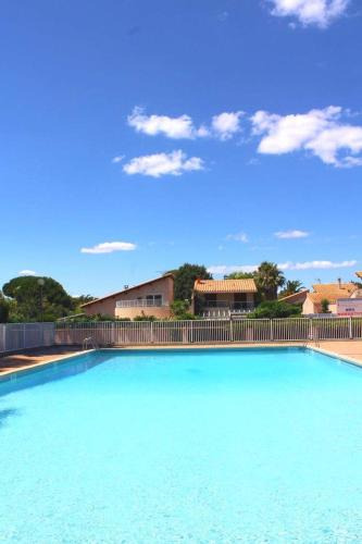 une grande piscine bleue avec une clôture dans l'établissement Joli studio terrasse avec piscine et parking, à Saint-Cyprien