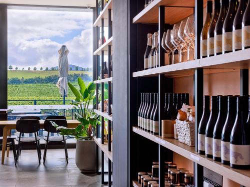a wine tasting room with a view of a field at Re’em Yarra Valley in Gruyere