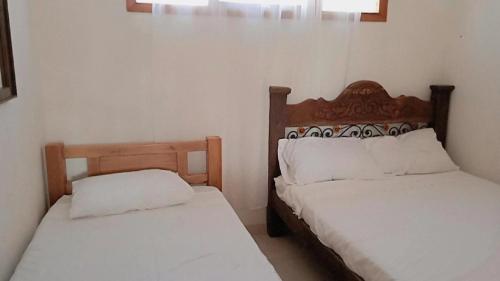 two beds sitting next to each other in a room at HOSTAL LA BOQUILLA in Cartagena de Indias