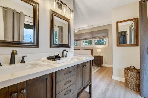 a bathroom with a sink and two mirrors at El Dorado- Cozy Retreat-Hot Tub-Upper Level in Pikeview