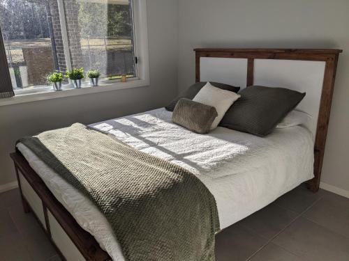 un letto in una camera da letto con due cuscini e una finestra di Country Lane a Denham Court