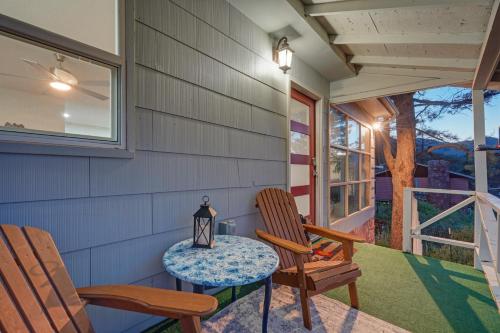 a porch with two chairs and a table at Hot Tub - Game Room - Wood Fireplace in Chipita Park