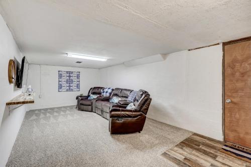 a living room with a leather couch and a tv at Hot Tub - Game Room - Wood Fireplace in Chipita Park