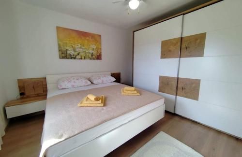 ein Schlafzimmer mit einem Bett mit zwei Hüten darauf in der Unterkunft Holiday house with a parking space Mundanije, Rab - 23396 in Rab