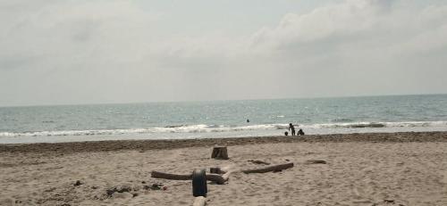 a sandy beach with people in the ocean and the water at HOSTAL LA BOQUILLA in Cartagena de Indias