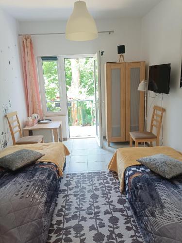 two beds sitting in a room with a balcony at Viking Rożnów in Rożnów