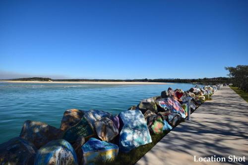a row of rocks on the side of a body of water at 59 Short in Nambucca Heads