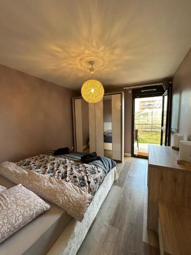 une chambre avec un lit et un lustre dans l'établissement T2 calme proche de la douane, à Ville-la-Grand