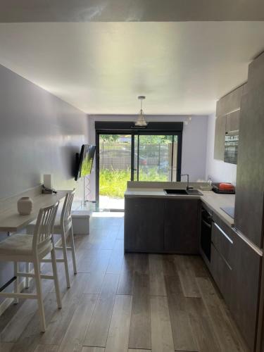 a kitchen with a table and chairs and a counter at T2 calme proche de la douane in Ville-la-Grand